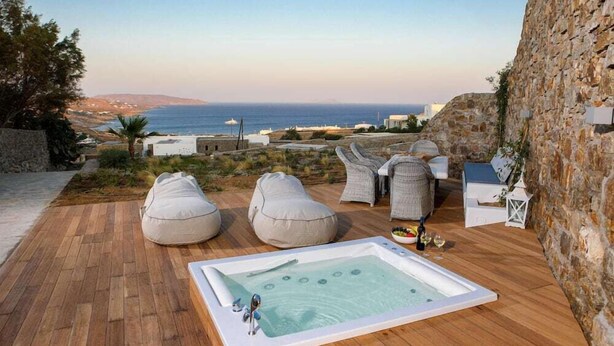 A rooftop terrace with a hot tub, seating area, and a view of the sea. - Kallisti (Mykonos)