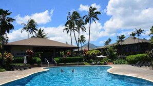 Ein Swimmingpool mit Liegestühlen und Palmen.