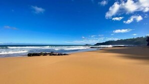Ein Strand mit blauem Himmel und ruhiger See.