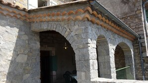 Ein Gebäude aus Stein mit Bogenportalen und einem Ziegeldach.