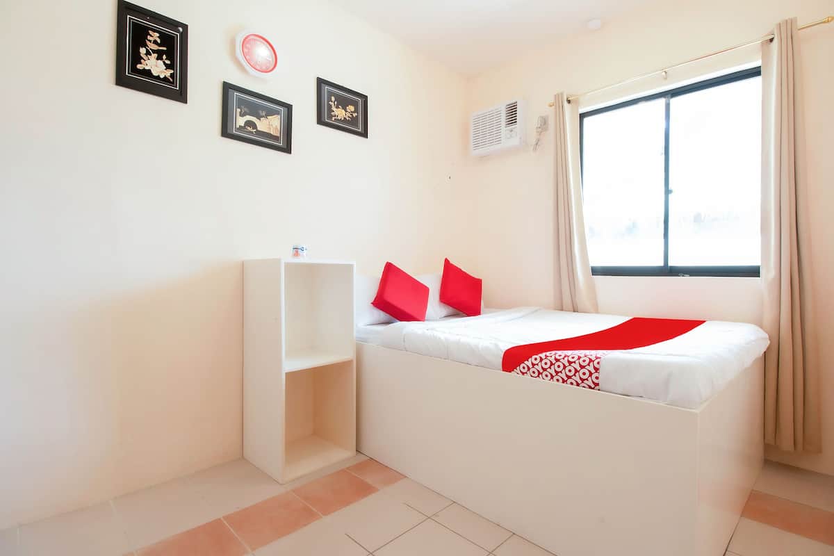 Une chambre à coucher avec un lit, une armoire, une fenêtre et des éléments décoratifs sur les murs.