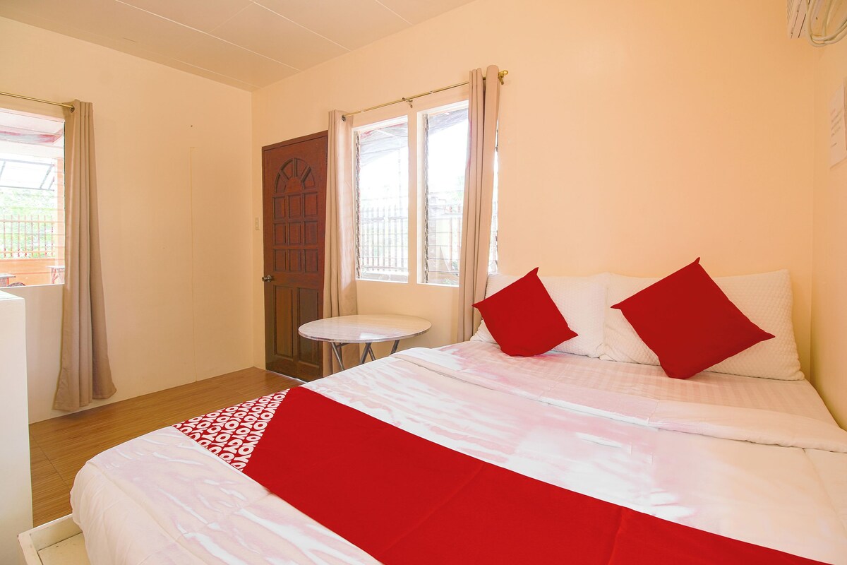 A neatly arranged bedroom with a bed, a small round table, and a door.