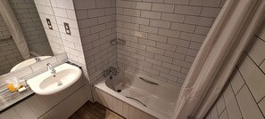 A bathroom with a sink, bathtub, and tiled walls. - The Boat & Horses Inn (Oldham)