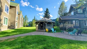 Un gazebo con tetto in tegole e una piccola zona relax con sedie.