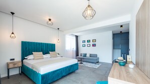 Une chambre moderne avec un grand lit, des tables de chevet, un bureau et un canapé.