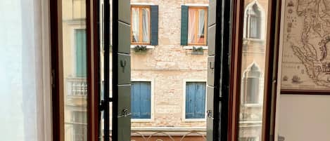 An open door with a view of a building with a sign reading "Fondamenta Rio Marn."