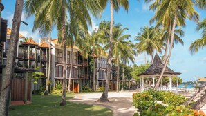 Een resort met meerlaags gebouwen, palmbomen, een prieel en een zwembad.
