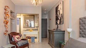 Een moderne slaapkamer met een bed, een stoel, een klein tafeltje en een dressoir.