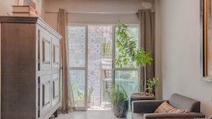 Een zithoek met een bank, een kast en potplanten.