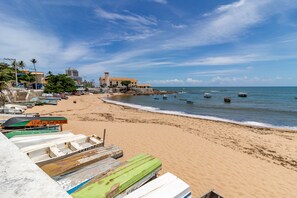 Una playa con barcos, un edificio y cielo despejado.