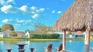 Un campo da golf con un padiglione a tetto di paglia, una piscina e un segnalino.
