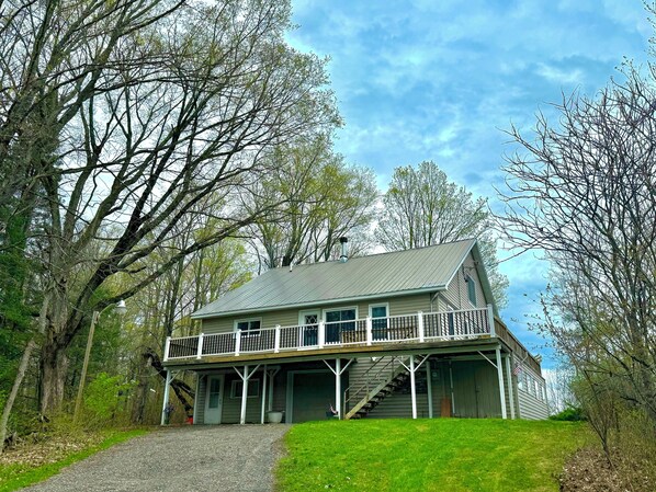A two-story house with a balcony, a covered porch, and a staircase leading to the upper level.
