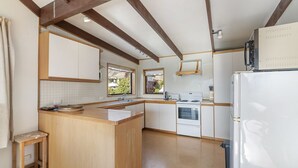 Eine Küche mit Holzausstattung, einer Kochinsel, einem Herd und einem Kühlschrank.