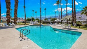 A swimming pool with lounge chairs and palm trees. - A Design-Forward Midcentury Residence in Central Palm Springs! (Palm Springs)
