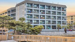 A multi-story hotel with balconies, a wooden deck, and a view of the beach. - Direct OCEANFRONT 3rd floor End unit Myrtle Beach Resort (Myrtle Beach)
