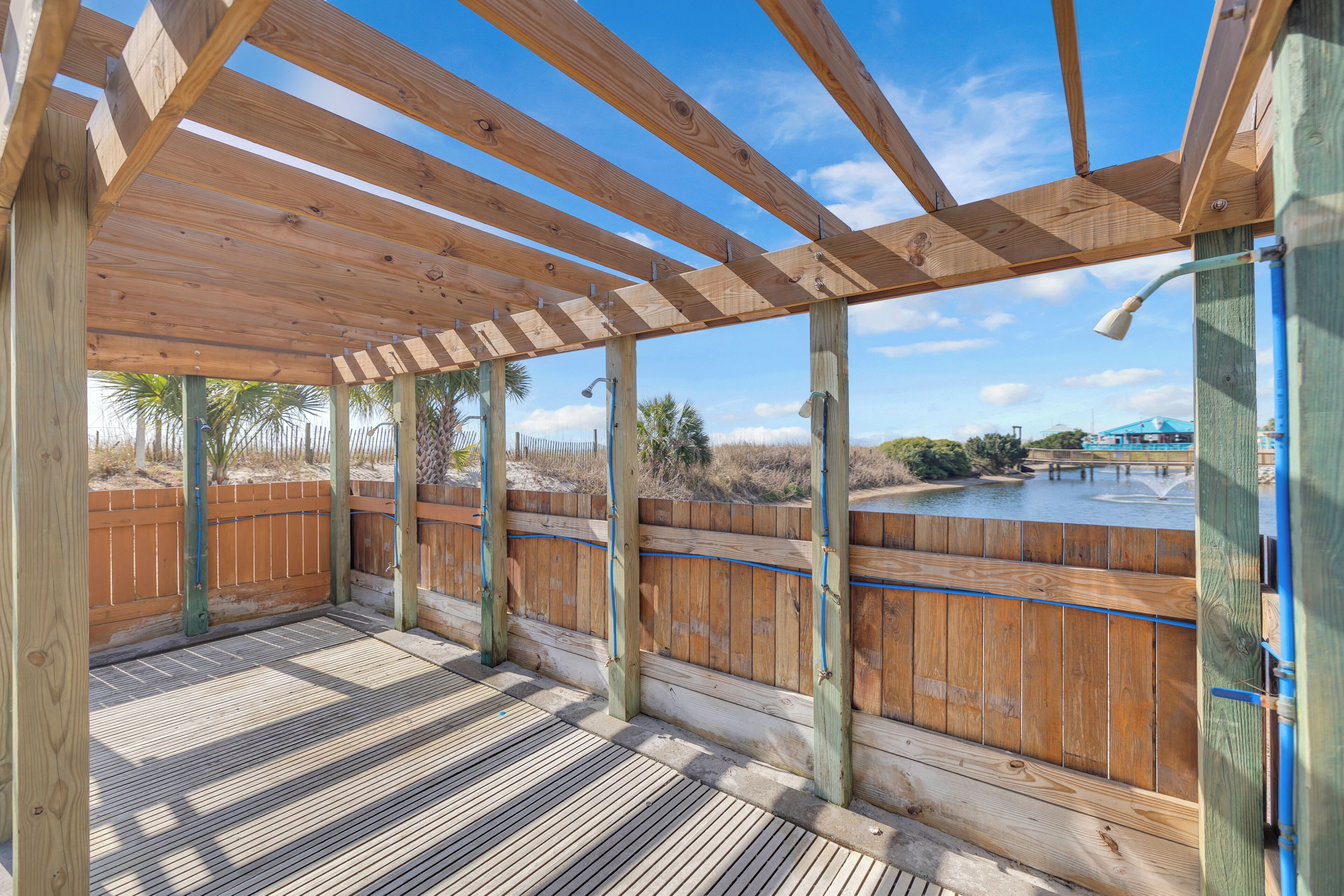 A wooden deck with a view of a water body and distant buildings.