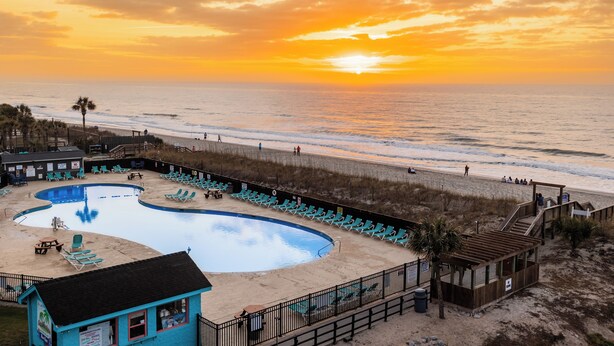 A beachside pool with lounge chairs, a lifeguard tower, and a boardwalk leading to the beach. - Direct OCEANFRONT 3rd floor End unit Myrtle Beach Resort (Myrtle Beach)
