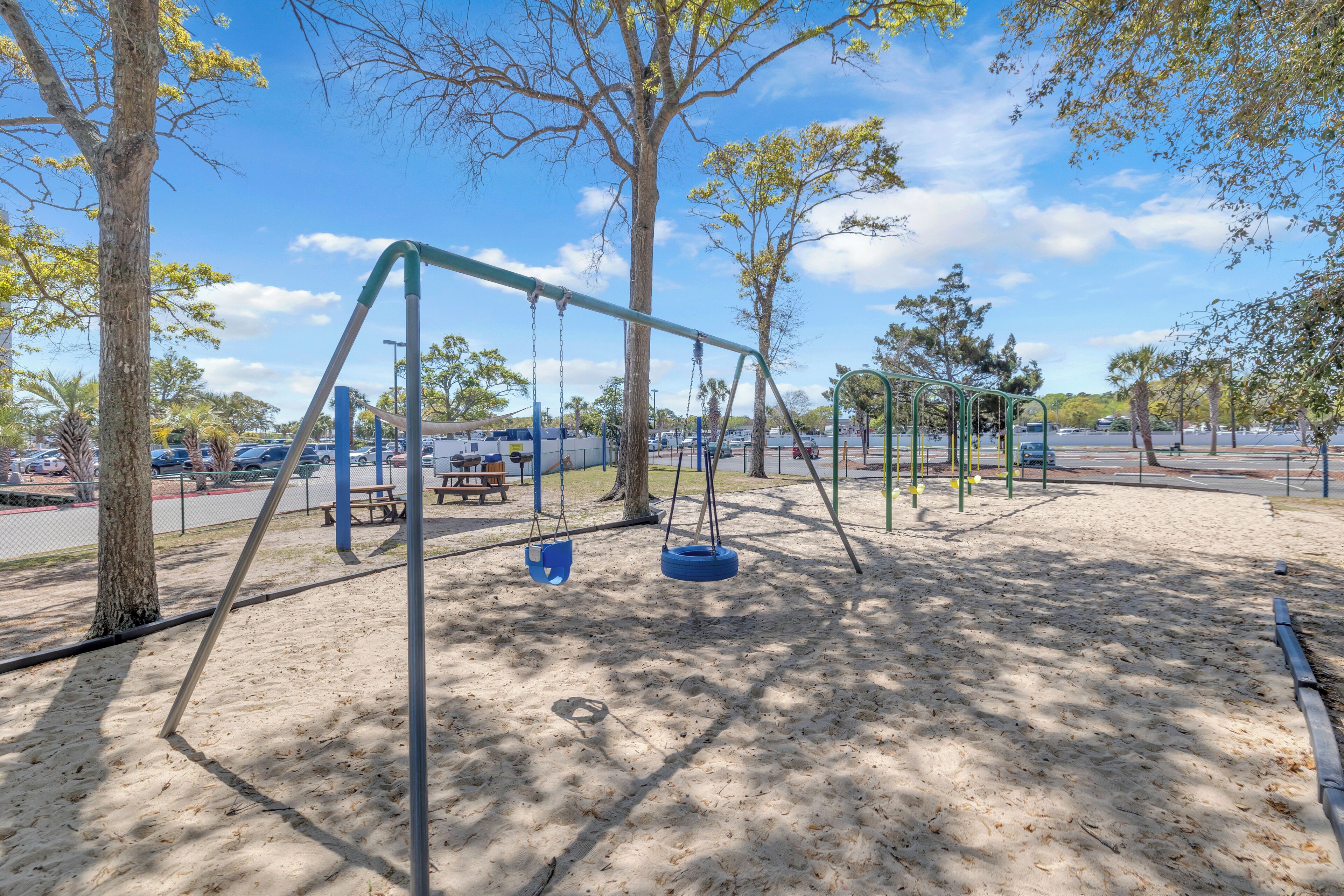 A playground with swings and a picnic table.