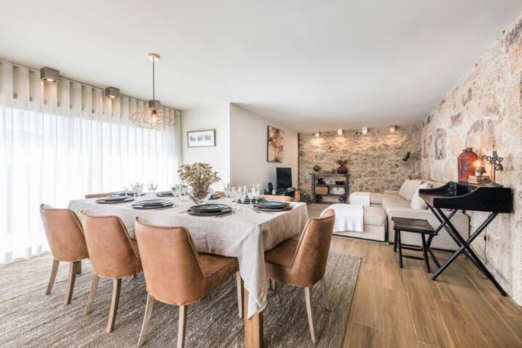 A dining area with a table set for six, surrounded by wooden chairs.