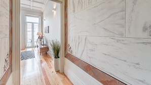 Ein Korridor mit Marmorwänden und Holzböden, der zu einem Zimmer mit Blick führt.