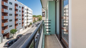Un moderno edificio de apartamentos con balcones, cielo despejado y vista a la calle.