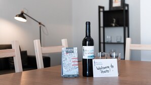 Una mesa con un mapa de la ciudad, una botella de vino y un cartel de bienvenida.