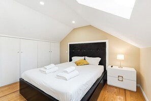 Ein modernes Schlafzimmer mit Bett, Nachttisch und Kleiderschrank.