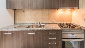 A modern kitchen with granite countertops, stainless steel appliances, and wooden cabinets.