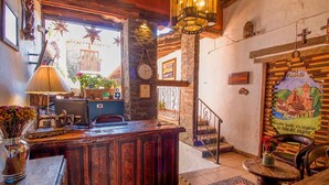 A rustic interior with a wooden reception desk, a clock, and a mural depicting a church. -  Hotel Mi Pueblito Tapalpa (Tapalpa)
