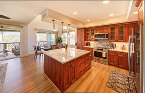 Enjoy cooking in this well-equipped kitchen with a large island, refrigerator, oven, and microwave.