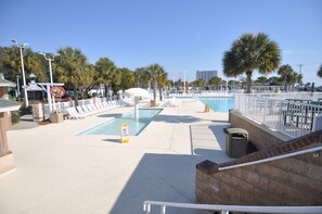 A pool area with a closed sign, lounge chairs, and a view of the ocean. - 1442 BEAUTIFUL BEACH HOUSE W/5 BRS, 3.5 BATHS! (Myrtle Beach)