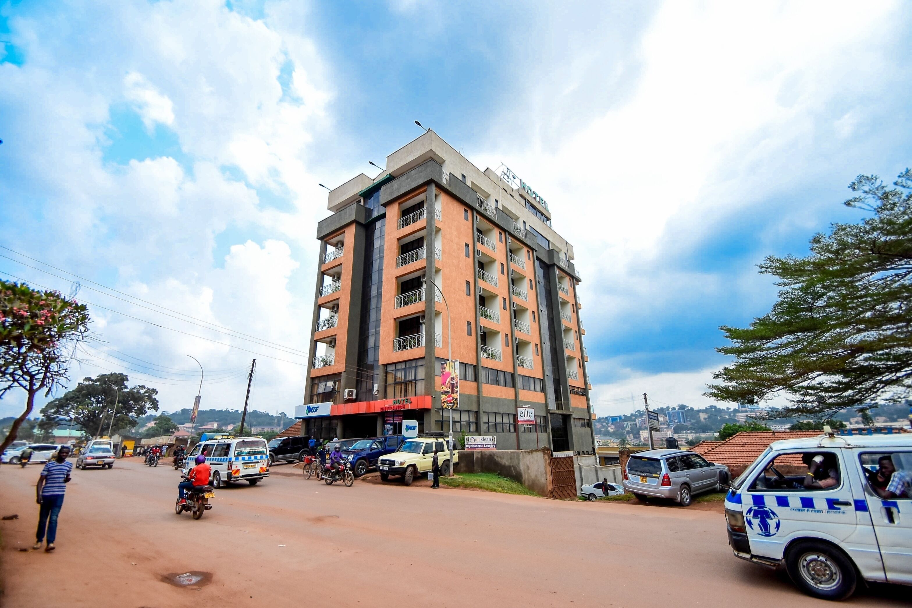 A multi-story building with balconies, a commercial ground floor, and a clear view of the sky.