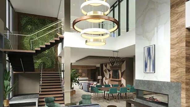 A spacious interior with a staircase, seating area, and a dining space. - Hilton Garden Inn Albuquerque Downtown (Albuquerque)