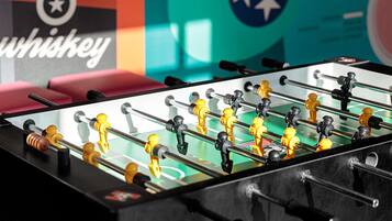 A foosball table with a clear view of the table's surface and the surrounding area.