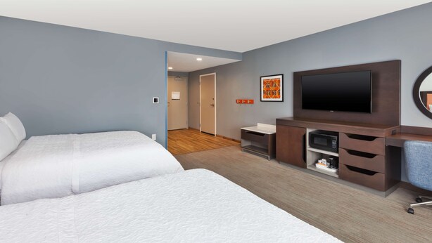 A hotel room with two beds, a TV, a desk with drawers, and a microwave. - Hampton Inn Danville, VA (Danville)