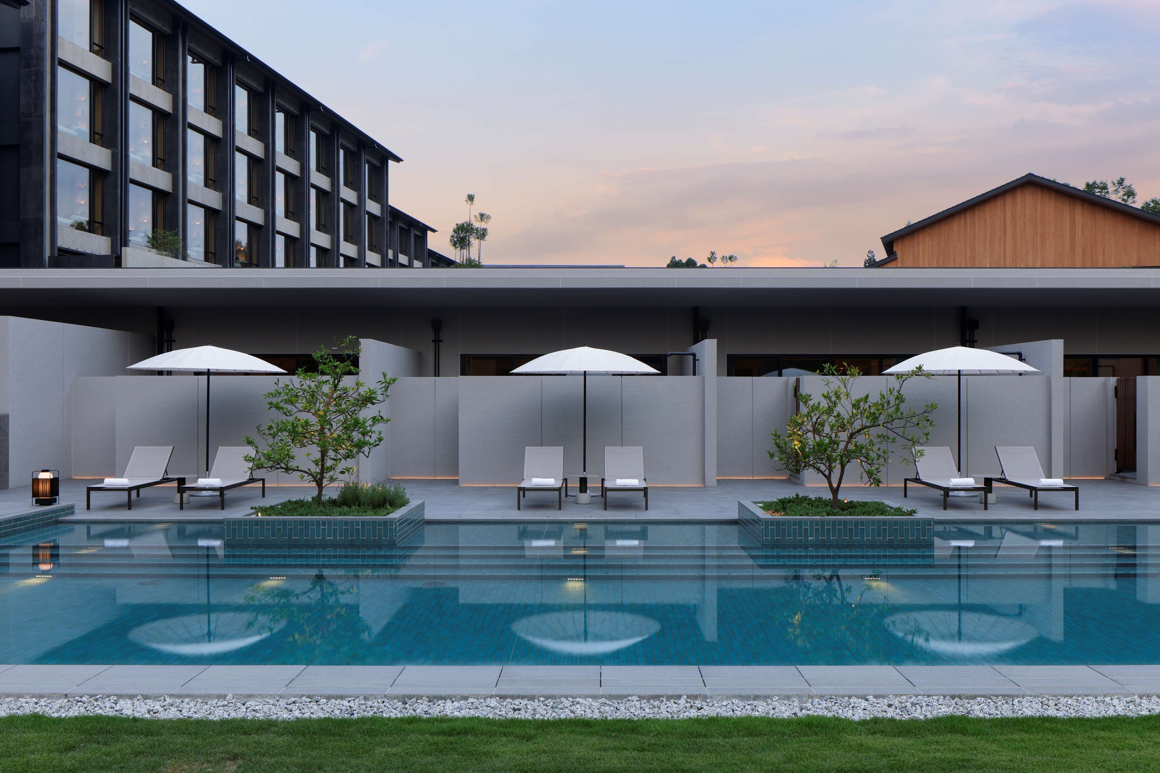 Una piscina al aire libre, sombrillas