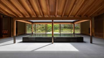 Spacious interior with a high ceiling and glass partition, featuring a large open area and minimalist design.