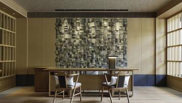 Un interior moderno con una mesa de madera, dos sillas y una pared con textura.