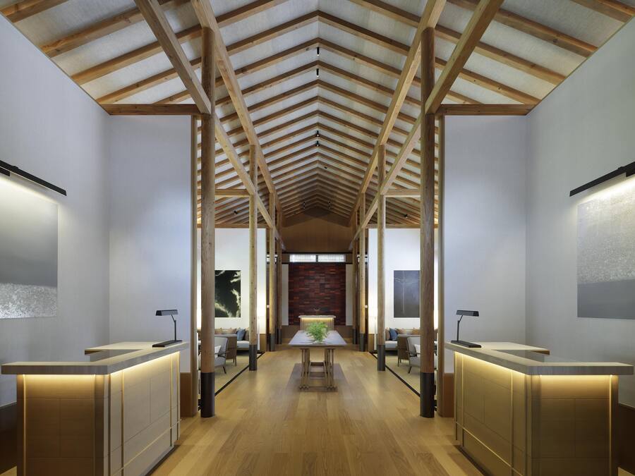 A hotel lobby with a high ceiling, wooden beams, and two reception desks.