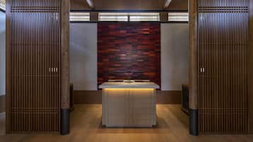 A modern bathroom with a wooden vanity, a tiled wall, and a wooden partition.