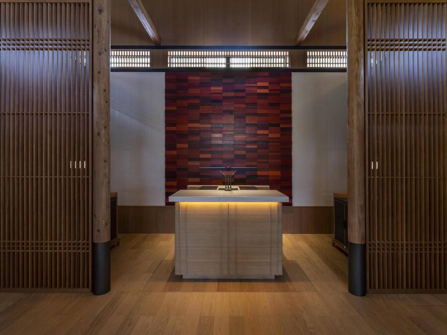 A modern bathroom with a wooden vanity, a tiled wall, and a wooden partition.