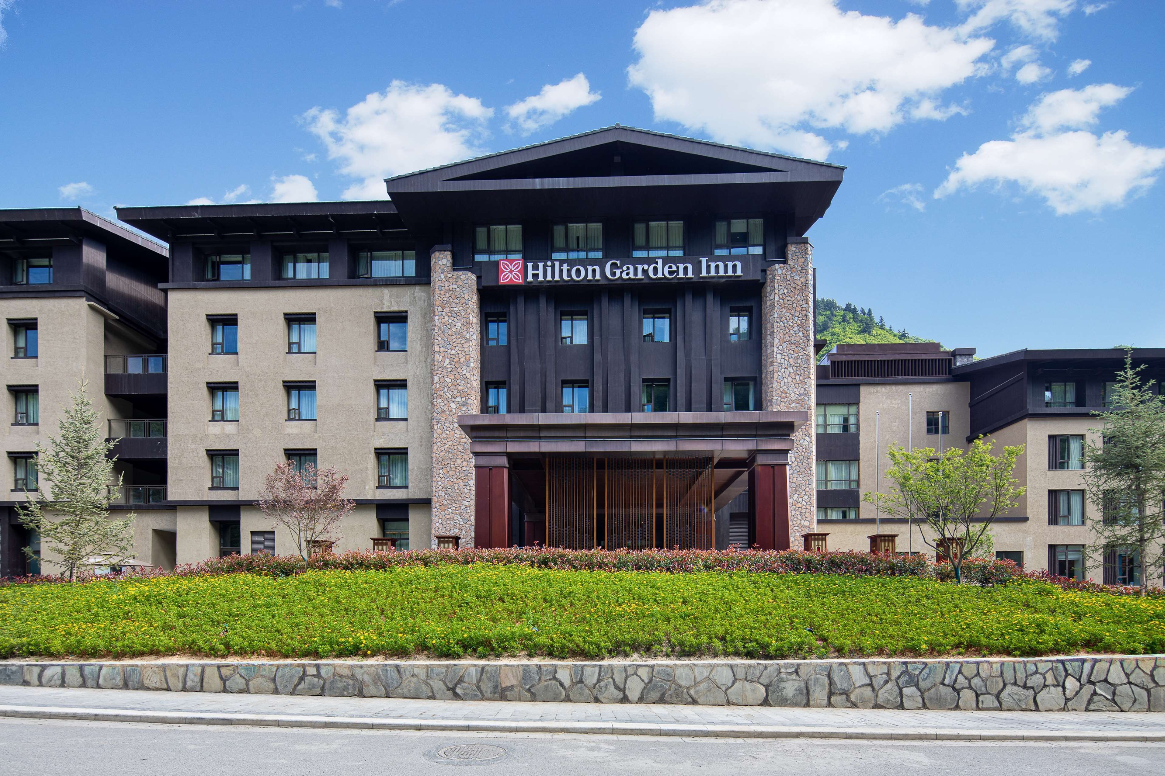 A Hilton Garden Inn hotel with a modern design, multiple floors, and a landscaped front garden.