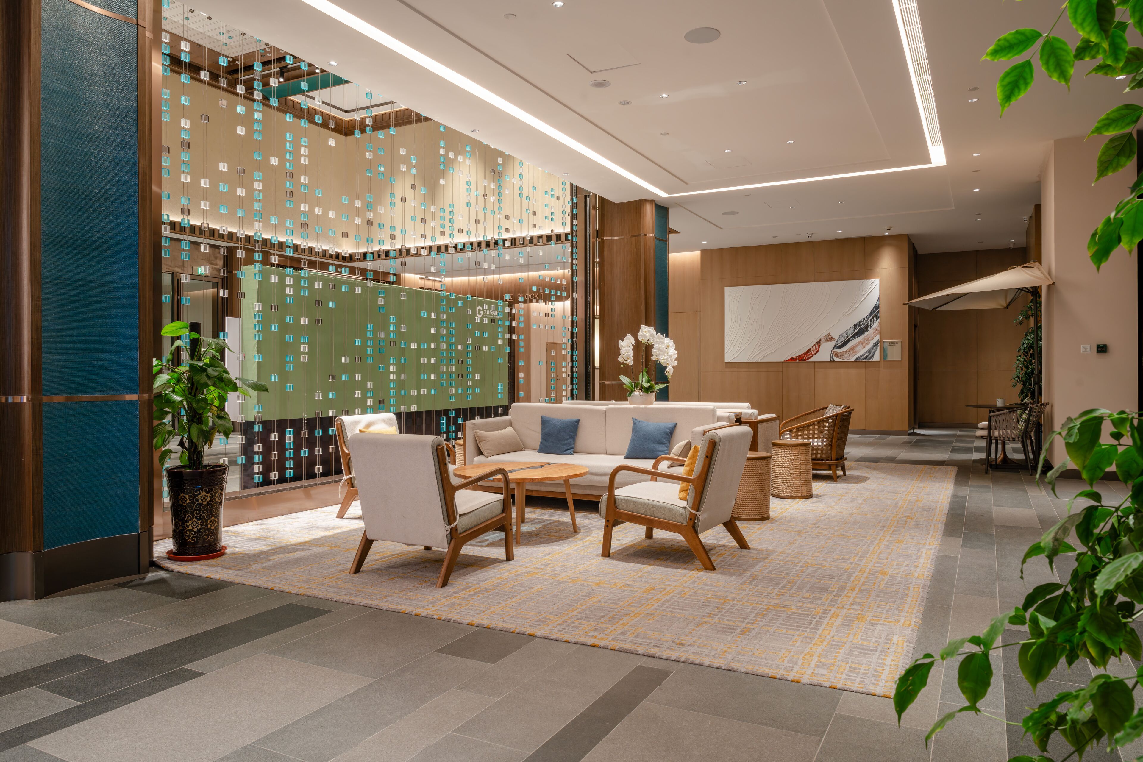 A modern lobby with a seating area, lockers, and a large abstract painting.