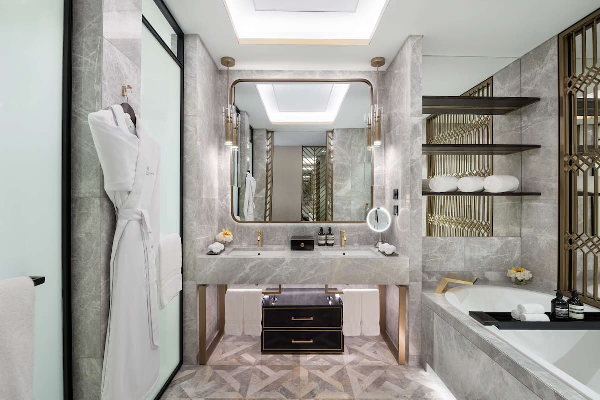 Un baño moderno con un espejo grande, una bañera y un tocador con lavabo.