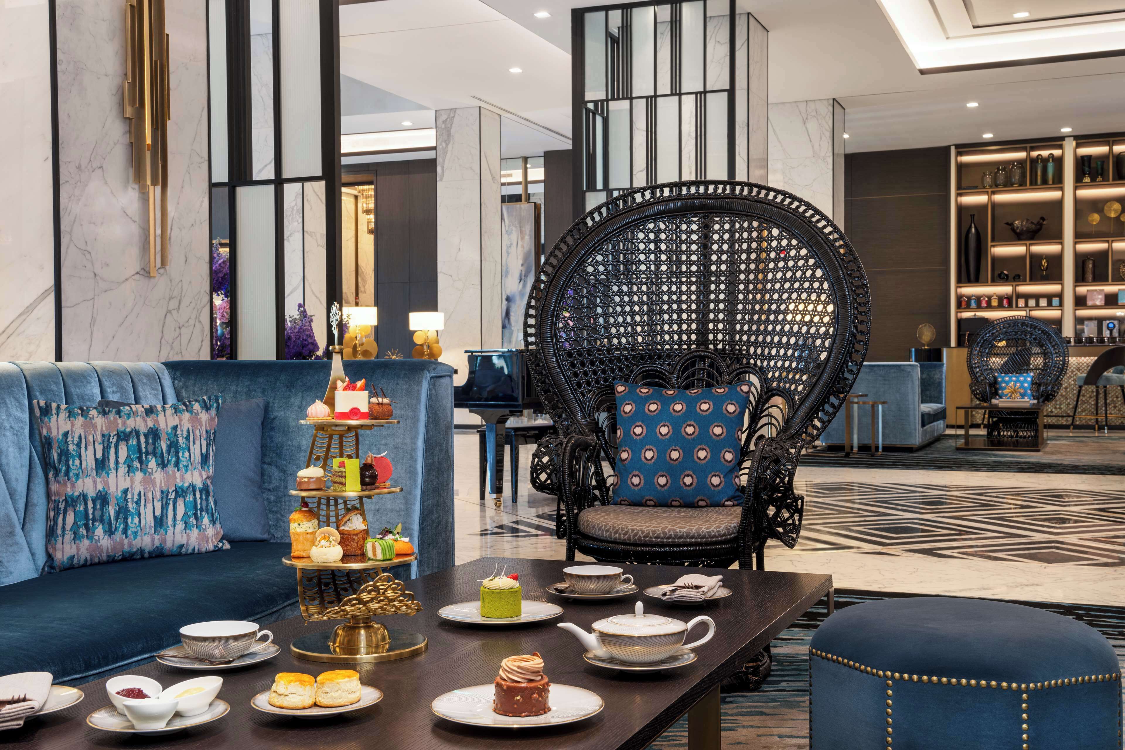 A modern lounge area with a tiered dessert display, comfortable seating, and a patterned floor.