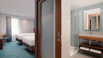 Une chambre d’hôtel équipée d’un lit, d’un bureau et d’un espace douche.