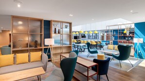 A modern lounge area with a sofa, chairs, and a dining table. - Hampton by Hilton Canterbury (Canterbury)
