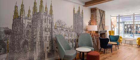 Un intérieur moderne agrémenté d’une grande fresque représentant une cathédrale, d’un plancher en bois et de mobilier contemporain.