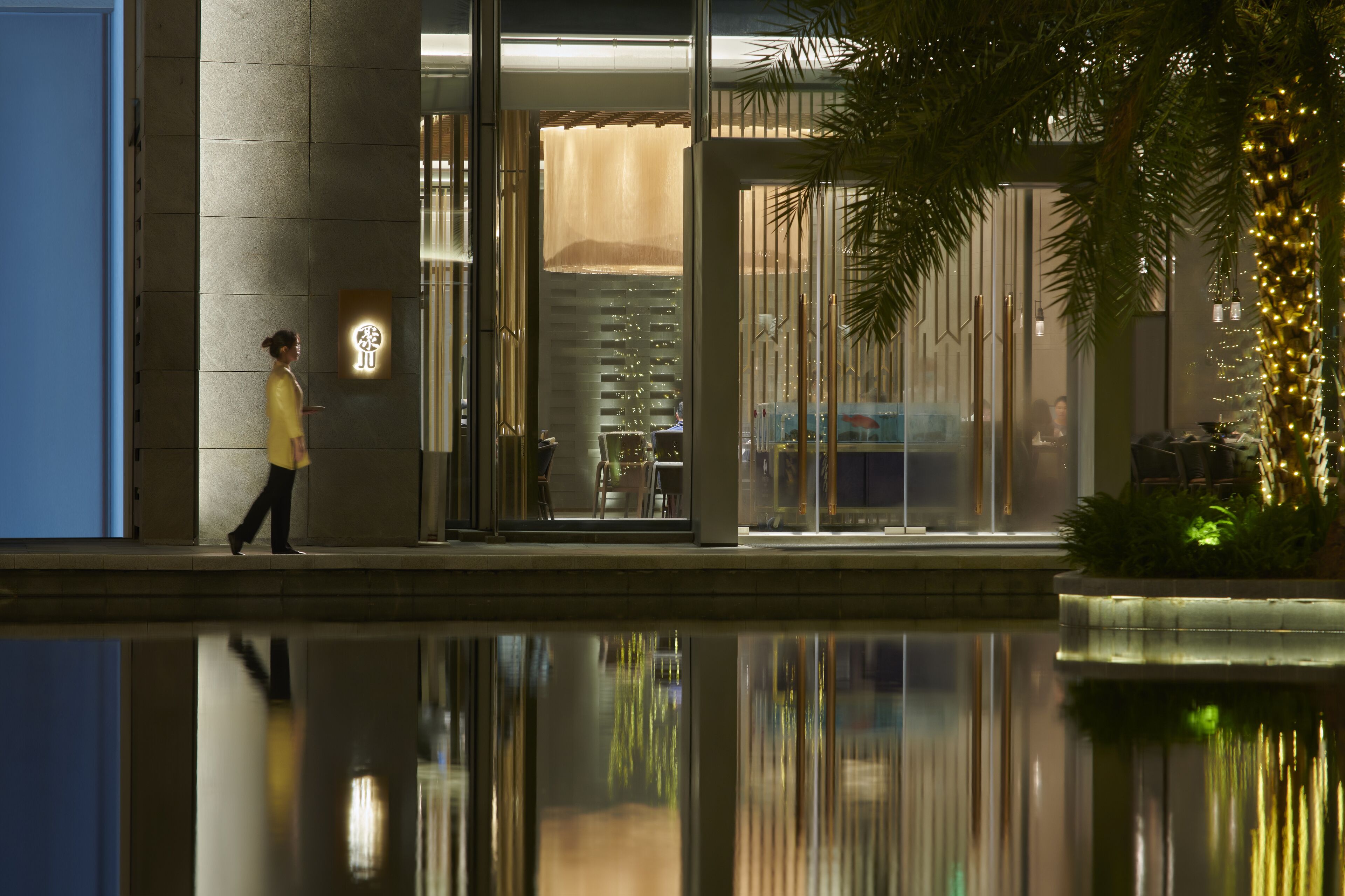 A modern building with a reflective pool in front.
