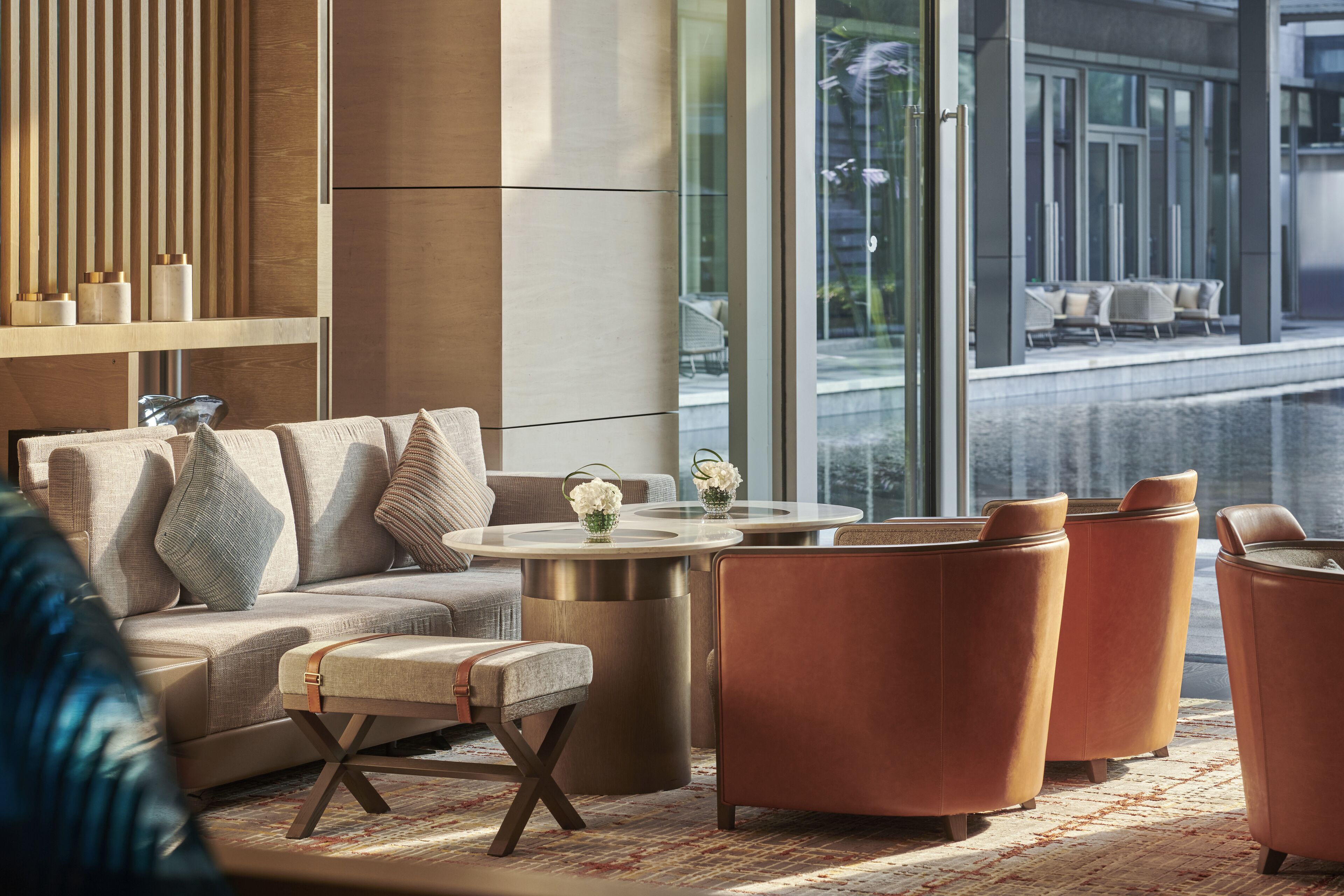 A modern lounge area with a sofa, armchairs, and a coffee table.